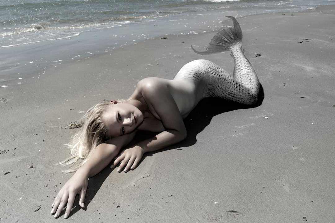 Boudoir picture of a woman as a mermaid on the beach