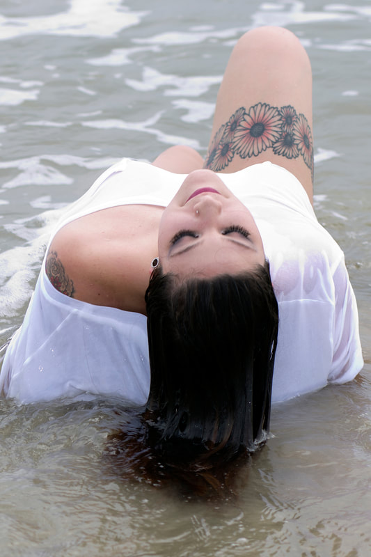 Boudoir portrait of a woman at the beach in the ocean wearing a white t-shirt